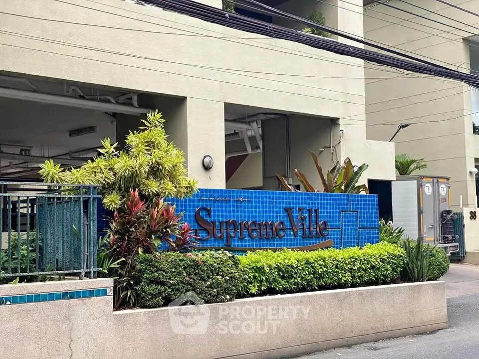 Elegant entrance of Supreme Ville with lush greenery and modern design.