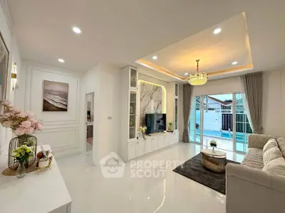 Luxurious living room with elegant decor and pool view, featuring a plush sofa and modern entertainment center.