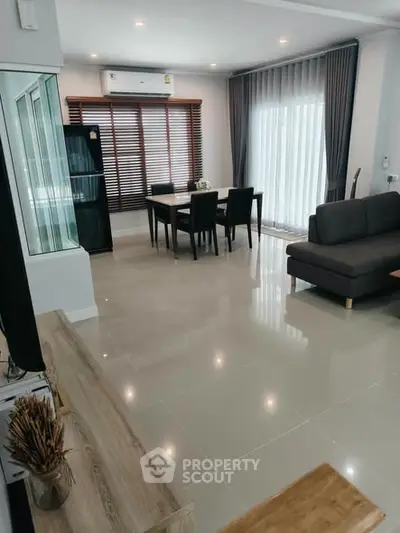 Spacious modern living room with elegant dining area and large windows for natural light.