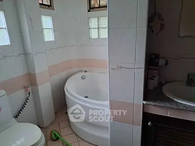 Cozy bathroom with corner bathtub and modern fixtures in a stylish home.