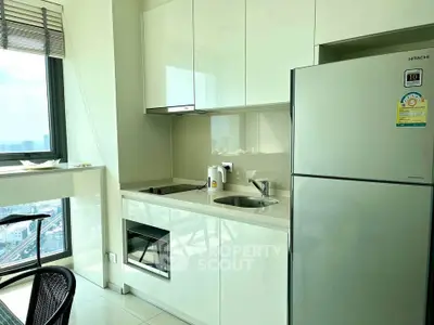 Modern kitchen with sleek cabinetry and stainless steel appliances in a high-rise apartment.