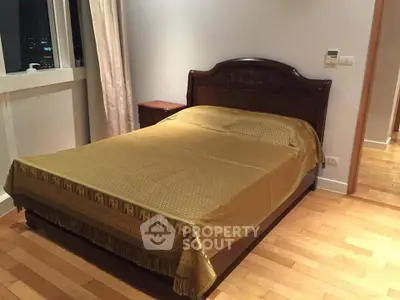 Cozy bedroom with wooden flooring and elegant bed in a modern apartment.