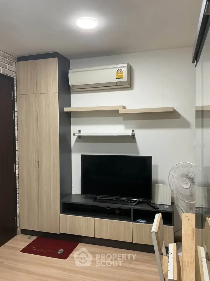 Modern living room with sleek TV unit and air conditioning in stylish apartment.