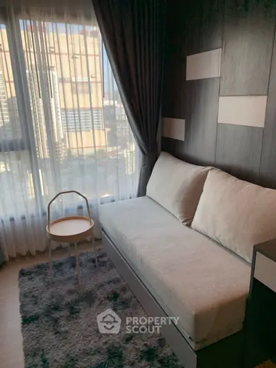 Cozy living room with modern decor and city view, featuring a plush sofa and stylish rug.