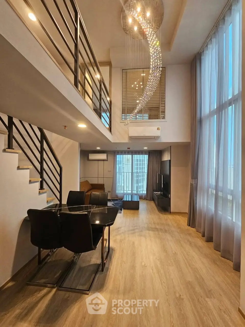 Luxurious modern living room with high ceilings and elegant chandelier