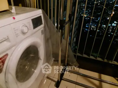 High-rise balcony with washing machine and city night view