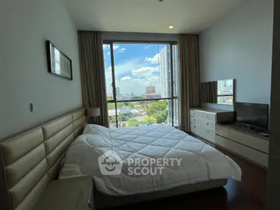 Modern bedroom with large window offering stunning city view, featuring cozy bed and sleek furniture.
