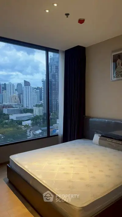 Modern bedroom with city view and large window in high-rise apartment