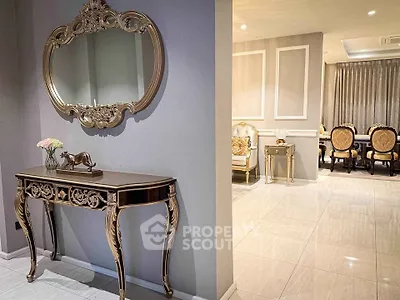 Luxurious living room with elegant furniture and ornate mirror, showcasing sophisticated interior design.