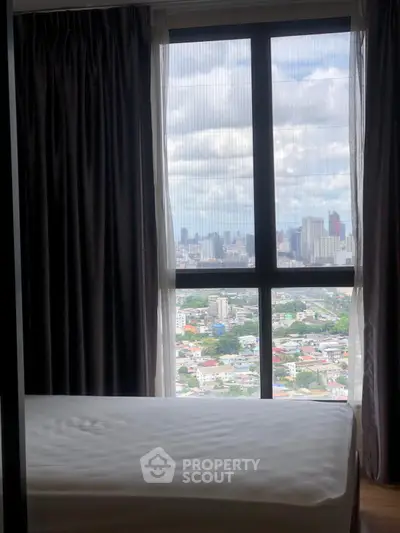 Stunning bedroom with panoramic city view through large window, offering a serene and luxurious living experience.