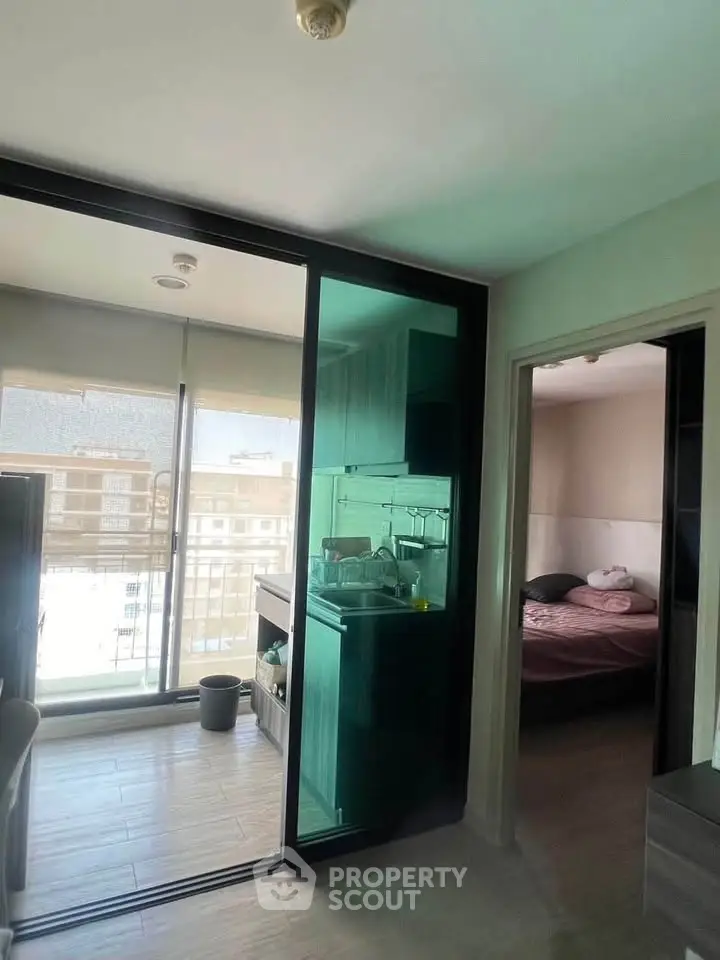 Modern apartment with glass partition kitchen and cozy bedroom, featuring large windows for natural light.