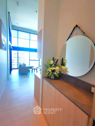 Modern apartment interior with stylish decor and large windows offering natural light.