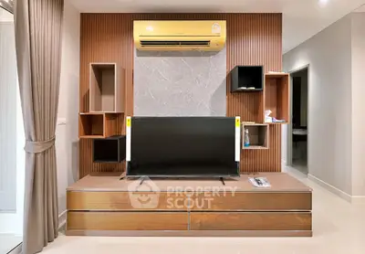Modern living room with stylish TV unit and air conditioning, featuring elegant wood paneling and sleek design.