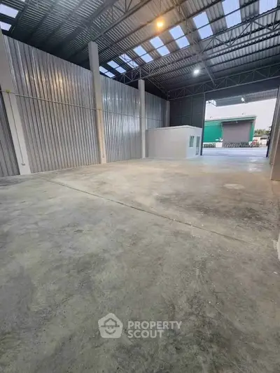 Spacious industrial warehouse with high ceilings and ample natural light.