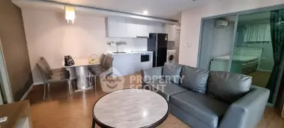 Modern open-plan living room with kitchen, dining area, and cozy seating in stylish apartment.