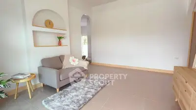 Charming living room with cozy armchair, decorative shelves, and soft rug in a bright, minimalist design.