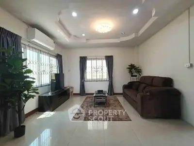 Spacious living room with modern decor, featuring a plush sofa, sleek TV unit, and elegant lighting.
