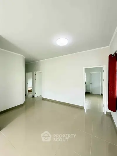 Spacious empty room with tiled flooring and white walls, perfect for customization.