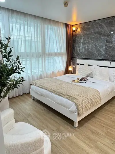 Modern bedroom with elegant decor and large window for natural light