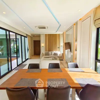 Luxurious open-plan living and dining area with modern decor and large windows