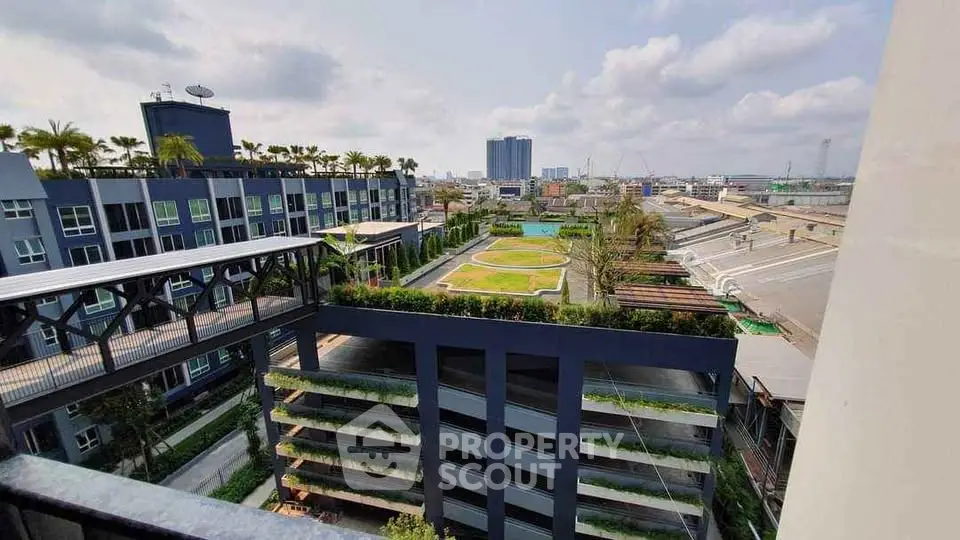 Stunning urban view from a modern building with lush green rooftop garden and cityscape backdrop.