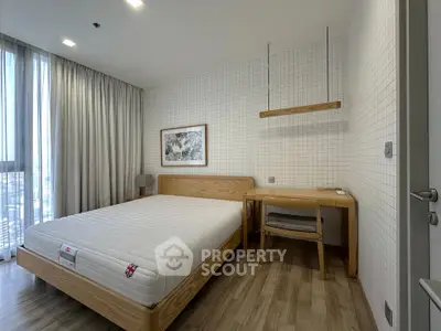 Modern bedroom with wooden furniture and large window for natural light.