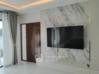 Modern living room with marble accent wall and large flat-screen TV