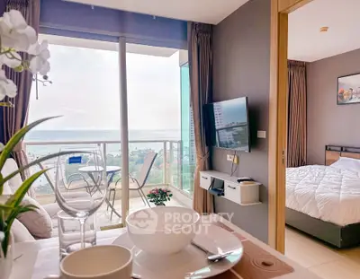 Modern apartment with stunning sea view from living room and balcony, featuring elegant decor and cozy bedroom.