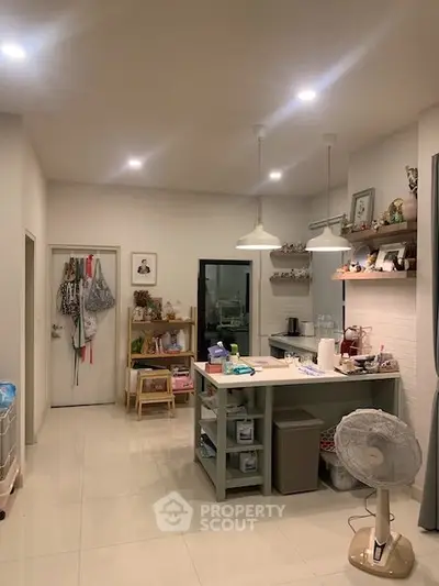 Charming open-layout kitchen with modern lighting and ample storage, perfect for cozy home living.