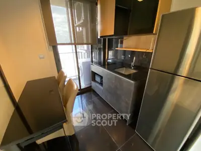 Modern compact kitchen with sleek appliances and dining area