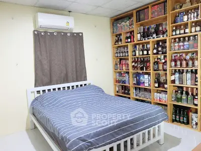 Cozy bedroom with air conditioning and extensive liquor collection display.