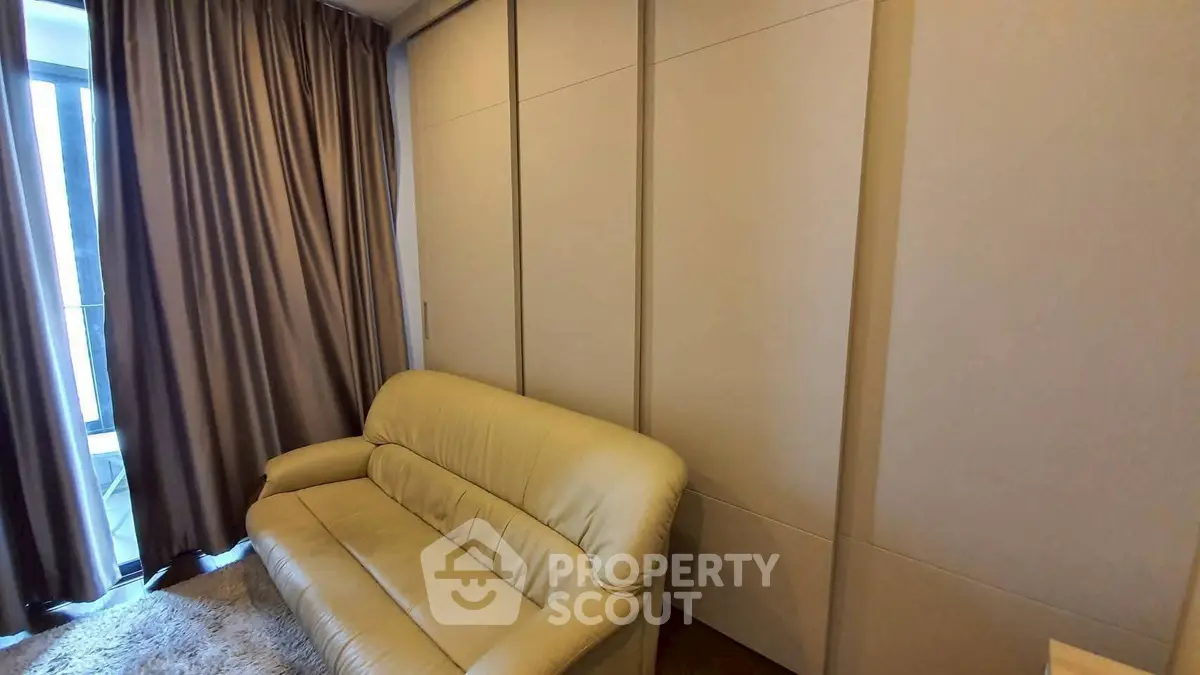 Cozy living room with beige sofa and floor-to-ceiling curtains, perfect for relaxation.