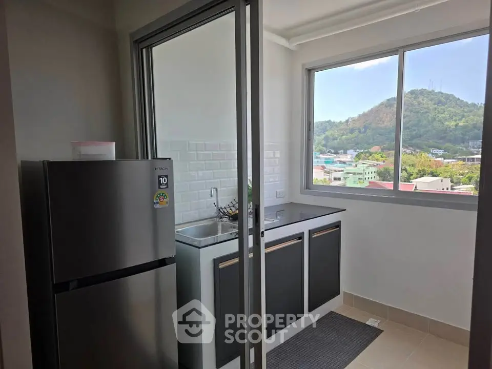 Modern kitchen with mountain view and sleek appliances in a bright apartment.