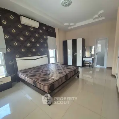 Spacious modern bedroom with stylish decor and ample natural light