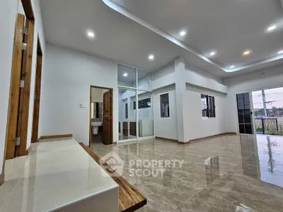 Spacious modern living room with glossy floors and balcony access
