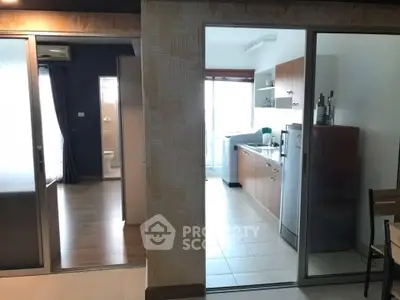 Modern apartment interior with kitchen and living area, featuring sleek design and ample natural light.