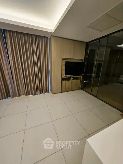 Modern living room with sleek TV unit and floor-to-ceiling curtains