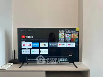Modern living room with smart TV displaying streaming apps on a sleek entertainment unit.