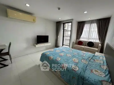 Modern bedroom with cozy decor and natural light, featuring a TV and air conditioning.