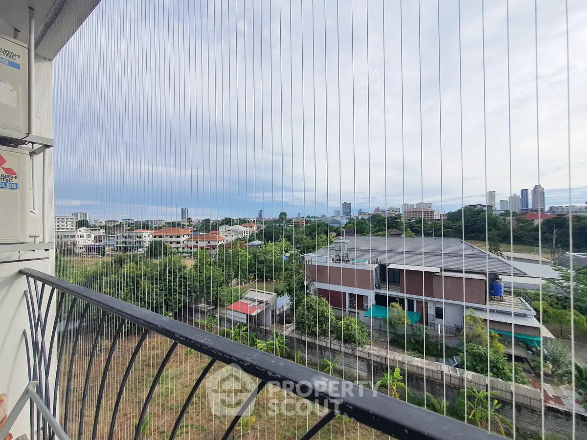 Stunning cityscape view from a secure balcony with protective netting, perfect for urban living.