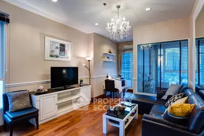 Elegant living room with chandelier and city view, featuring modern furniture and hardwood floors.