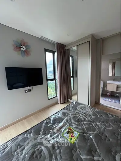 Modern bedroom with wall-mounted TV and large window offering city views