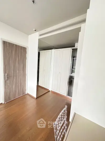 Modern bedroom with wooden flooring and built-in wardrobe in a stylish apartment.