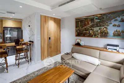Modern living room with open kitchen, featuring stylish decor and comfortable seating.