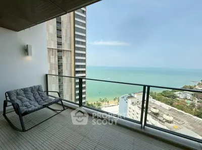 Stunning high-rise balcony with breathtaking ocean view and cozy seating area.