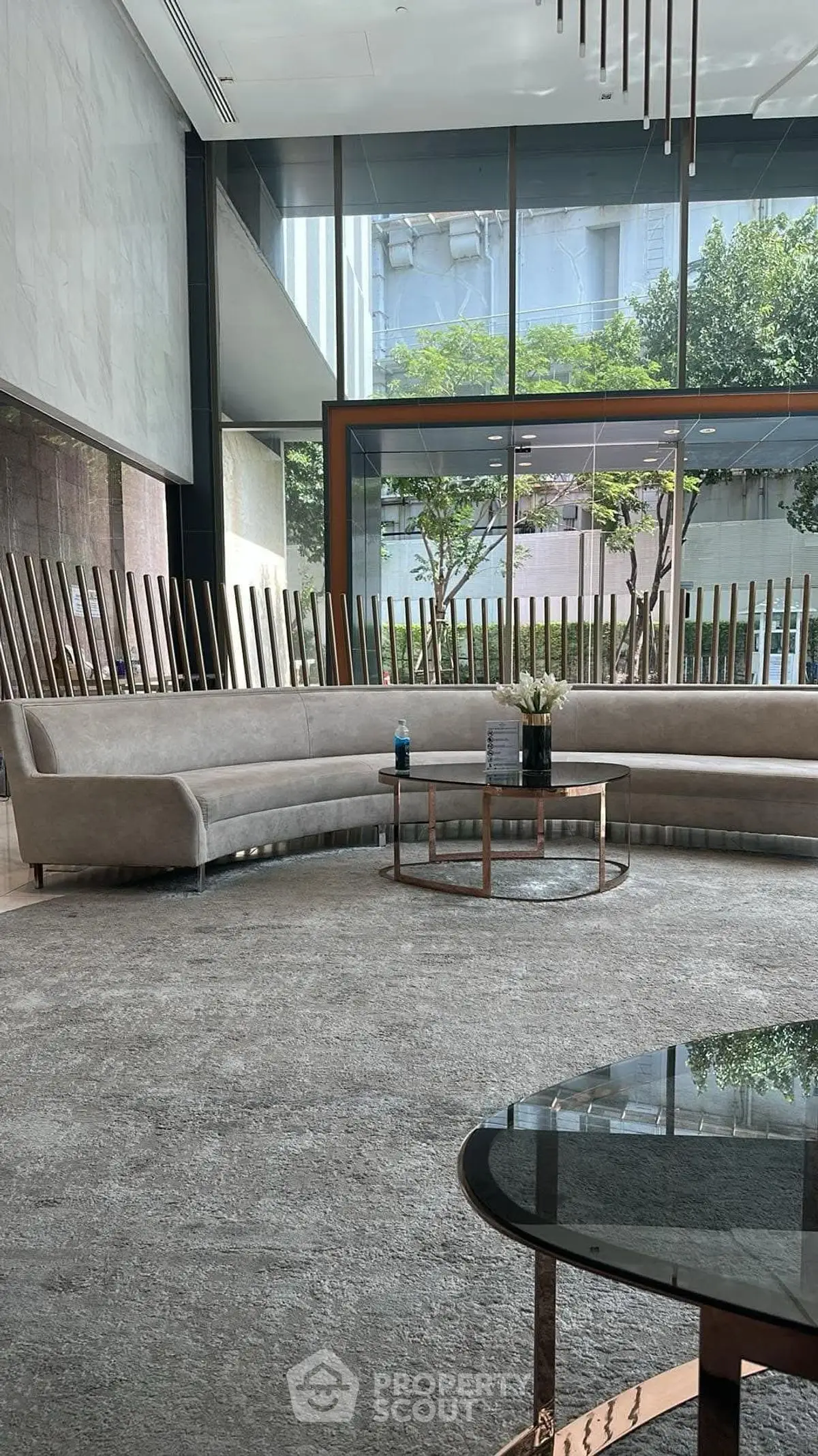 Luxurious modern living room with elegant sofas and large windows offering a serene garden view.