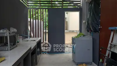Modern outdoor kitchen with sleek countertops and washing machine, perfect for convenient living.