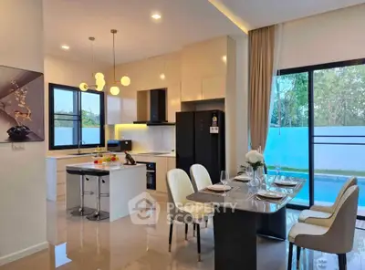 Modern kitchen and dining area with pool view, featuring sleek design and elegant furnishings.