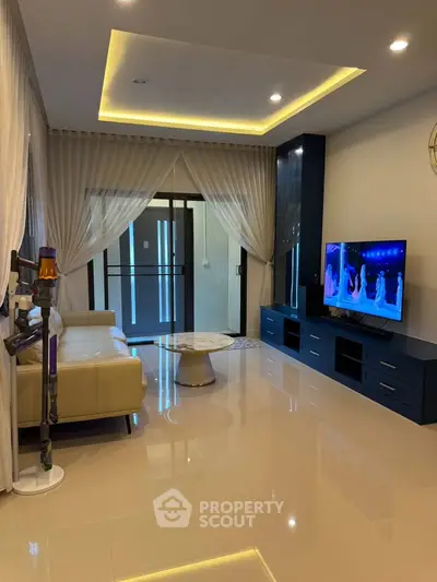 Modern living room with sleek design, featuring a large TV, elegant curtains, and stylish furniture.