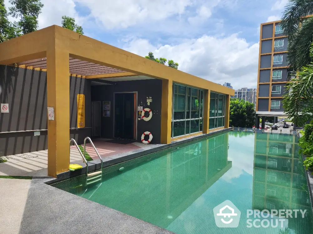 Inviting poolside area with modern amenities and lush greenery, perfect for relaxation and entertainment in a luxury residential complex.